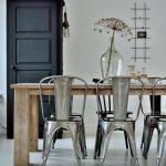 Salle à manger avec table en bois associée aux chaises Tolix en acier